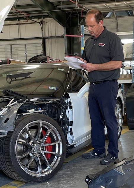 Parole Project client Chris Timon double checks a parts list before assigning the repair to his crew of collision repair technicians.