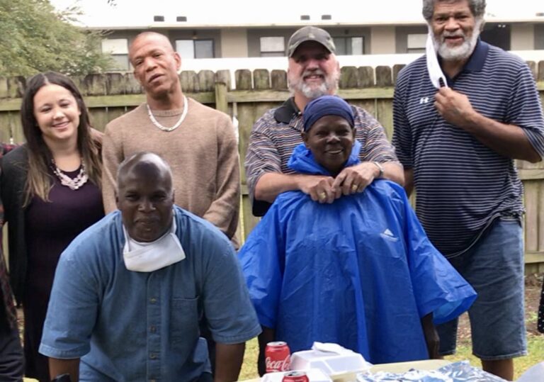 Parole Project clients and community members in the backyard of Redemption Homes.