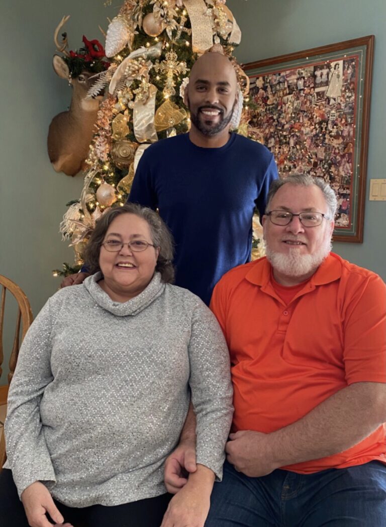 Parole Project client Jeff Haggins with his parents in front of a Christmas tree
