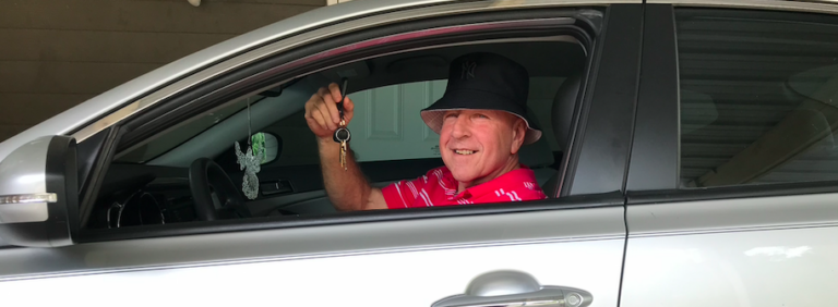 Eugene Cossich smiling holding up the keys to his car