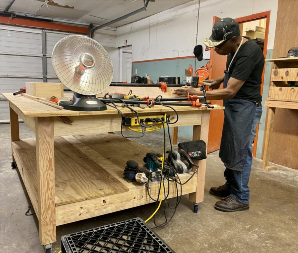 Theortric Givens works on the drawers of a custom cabinet in his workshop