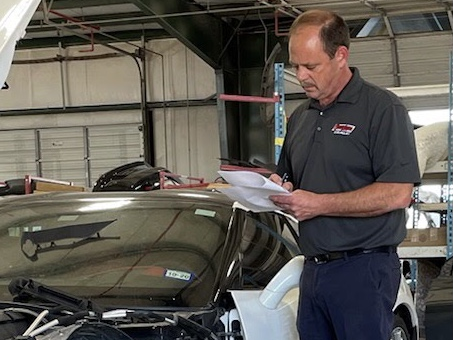 Parole Project client Chris Timon double checks a parts list before assigning the repair to his crew of collision repair technicians at a Baton Rouge automotive dealership.