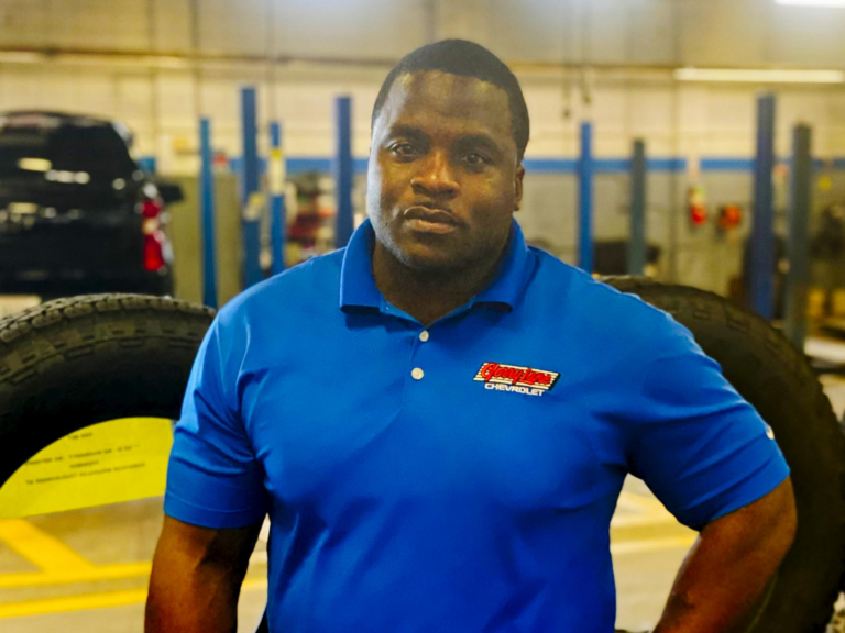Jadaw, standing in front of the service department, is making a name for himself in the service field through his talent, dedication, and hard work. He never misses an opportunity to express appreciation for the support of Parole Project and his family